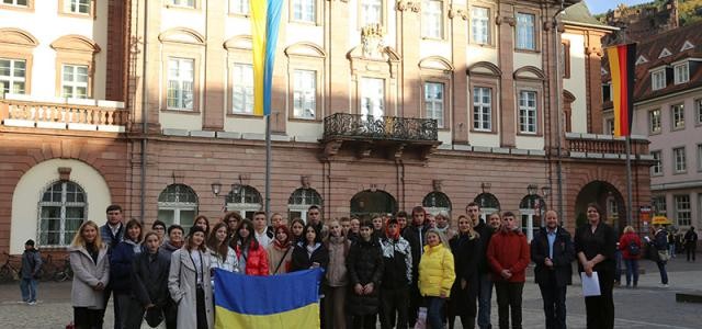 Gruppe Jugendlicher aus der Ukraine mit Ukraineflagge vor dem Rathaus