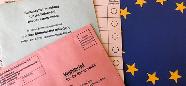 Wahlunterlagen der Europawahl mit EU-Flagge im Hintergrund