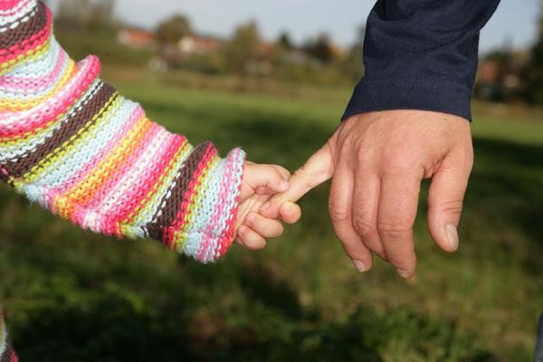 Kinderhand hält erwachsene Hand