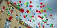 Bunte Luftballons schweben vor der Tiefburgschule 