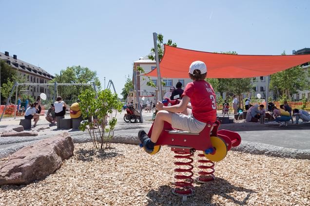 Junge sitzt auf einem Spielgerät auf dem Spielplatz