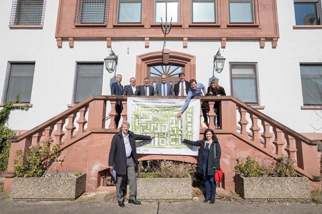 Thomas Diehl (Lebenshilfe), Ursula Bork (Montessori-Zentrum) und Franziska Meier und Nicolai Ferchl (Collegium Academicum) zeigen auf dem Rahmenplan für US Hospital ihre jeweils künftigen Standorte. Außerdem zu sehen sind Ronald Odehnal und Gerald Kraus (GGH), Bürgermeister Hans-Jürgen Heiß, Oberbürgermeister Prof. Dr. Eckart Würzner und Erster Bürgermeister Jürgen Odszuck. (Foto: Rothe)