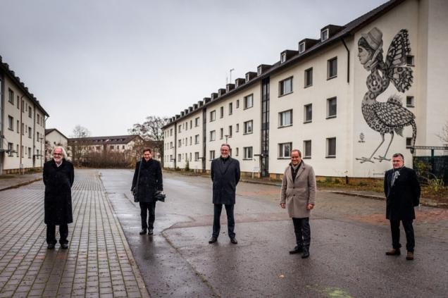 Männer stehen auf dem Gelände von Patrick-Henry-Village.