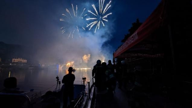 Feuerwehrleute schauen sich das Feuerwerk vom Behelfslöschbott aus an