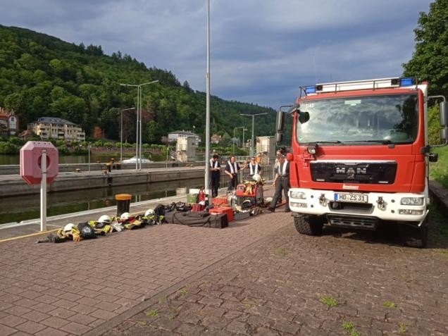 Feuerwehrleute entnehmen Geräte aus einem Feuerwehrfahrzeug