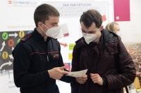 Ein Feuerwehrmann im Gespräch mit einem Studenten