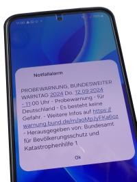 Screenshot eines Handybildschirms mit einer Testwarnmeldung über Cell Broadcast am