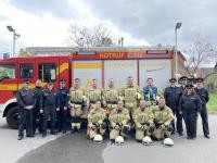 Gruppenbild der Mannschaft, ihrer Ausbilder und der Schiedsrichter vor einem Feuerwehrfahrzeug