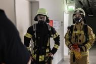 Zwei Lehrgangsteilnehmer mit angelegtem Atemschutzgerät erhalten ihren Einsatzbefehl