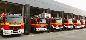 Feuerwehrfahrzeuge stehen vor den Hallentoren der Feuerwache