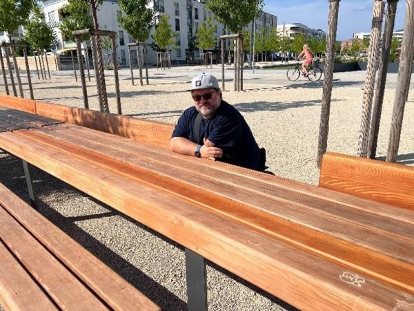 Ein Mann sitzt an einem Tisch im Freien