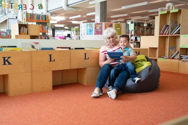 Eine ältere Frau liest einem Jungen etwas vor (Foto: Kempf)