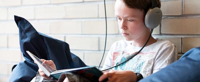 Junger Jugendlicher an Abhörstation mit Buch. (Foto: Kempf)