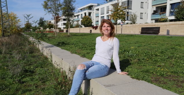 Frau sitzt an der Promenade in der Sonne (Foto: Stadt Heidelberg)