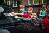 Kinder legen Flyer auf die Windschutzscheibe eines Autos. (Foto: Tobias Dittmer)