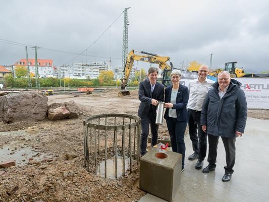 20. November 2023: Erster Bürgermeister Jürgen Odszuck, Elke Zimmer, Staatssekretärin im Verkehrsministerium Baden-Württemberg, Klaus-Peter Hofbauer, Leiter des Tiefbauamts, und Eckhard Horwedel von der DSK legen die Zeitkapsel in den Grundstein der neuen Gneisenaubrücke, der sich nahe des Luxur-Kinos in der Bahnstadt befindet. (Foto: Rothe) Vier Personen auf einer Baustelle