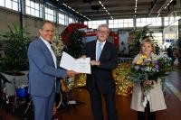 Oberbürgermeister Würzner überreicht Herrn Friedel eine Urkunde. Daneben steht Frau Friedel mit einem Blumenstrauß.