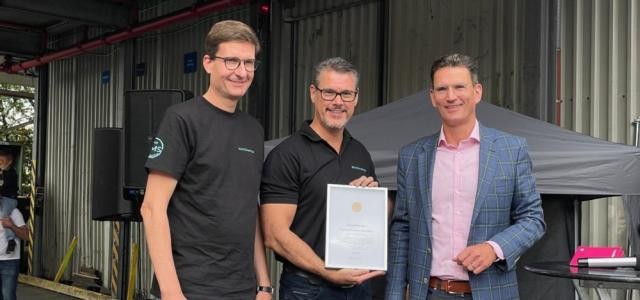 Christian Staab, Dr. Martin Rößing und Marc Massoth bei der Urkundenübergabe. Dr. Martin Rößing steht in der Mitte und hält die eingerahmte Urkunde.
