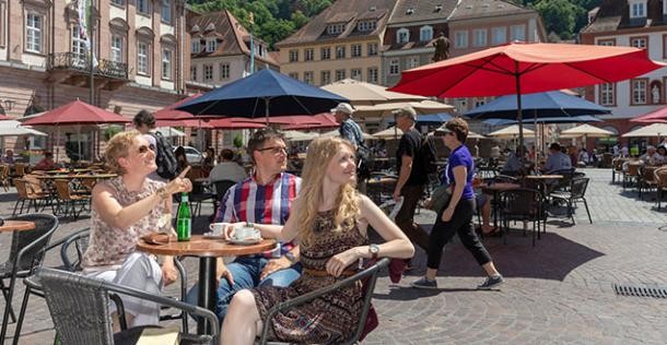 Gastronomie auf dem Heidelberger Marktplatz (Foto: Buck) Gastronomie-Tisch mit drei Gästen auf dem Heidelberger Marktplatz (Foto: Buck)