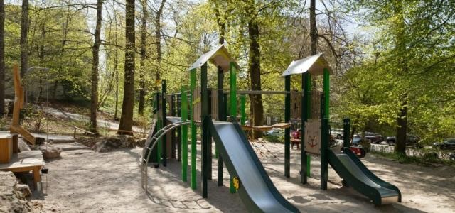 Spiel- und Klettergerüst mit zwei Rutschen auf einem Spielplatz.
