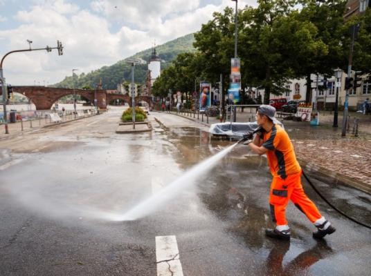 Ein Arbeiter der Stadt Heidelberg säubert die Straße vom Schlamm. 