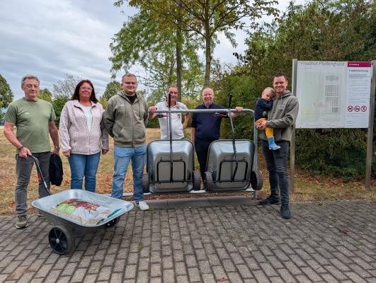 Hans Bopp, Gabi Beisel, Marvin Brusius (von links) und Julian Zimprich (rechts) nahmen als Vertretende des Stadtteilvereins Pfaffengrund gemeinsam mit Vertretern der Stadt die neue Handwagenstation offiziell in Betrieb. Ab sofort können Besuchende des Friedhofs im Pfaffengrund die Transportkarren kostenlos nutzen. (Bildnachweis: Stadt Heidelberg) Hans Bopp, Gabi Beisel, Marvin Brusius (von links) und Julian Zimprich (rechts) als Vertretende des Stadtteilvereins Pfaffengrund stehen gemeinsam mit Vertretern der Stadt und den neuen Transportkarren vor dem Friedhof im Pfaffengrund.