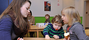 Educator with two small children looking at picture book