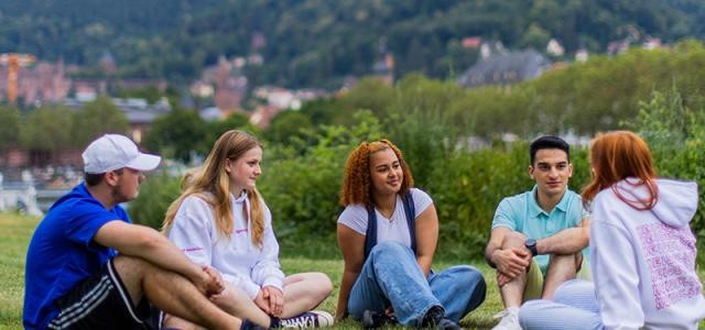 5 Jugendliche sitzen auf der Neckarwiese