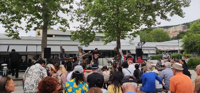 Band spielt unter freiem Himmel vor Forum, Publikum sitzt davor