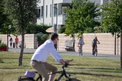 Menschen fahren auf der Bahnstadtpromenade Fahrrad