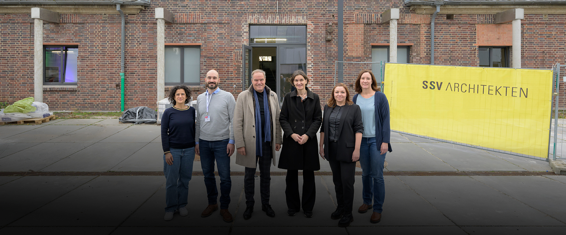 Gruppenfoto vor niedrigem Backsteingebäude